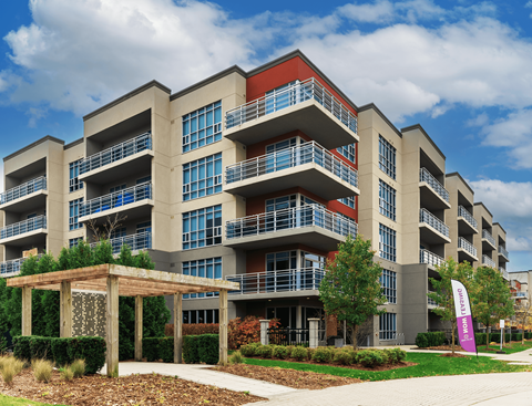 A large apartment building with a balcony on each floor.