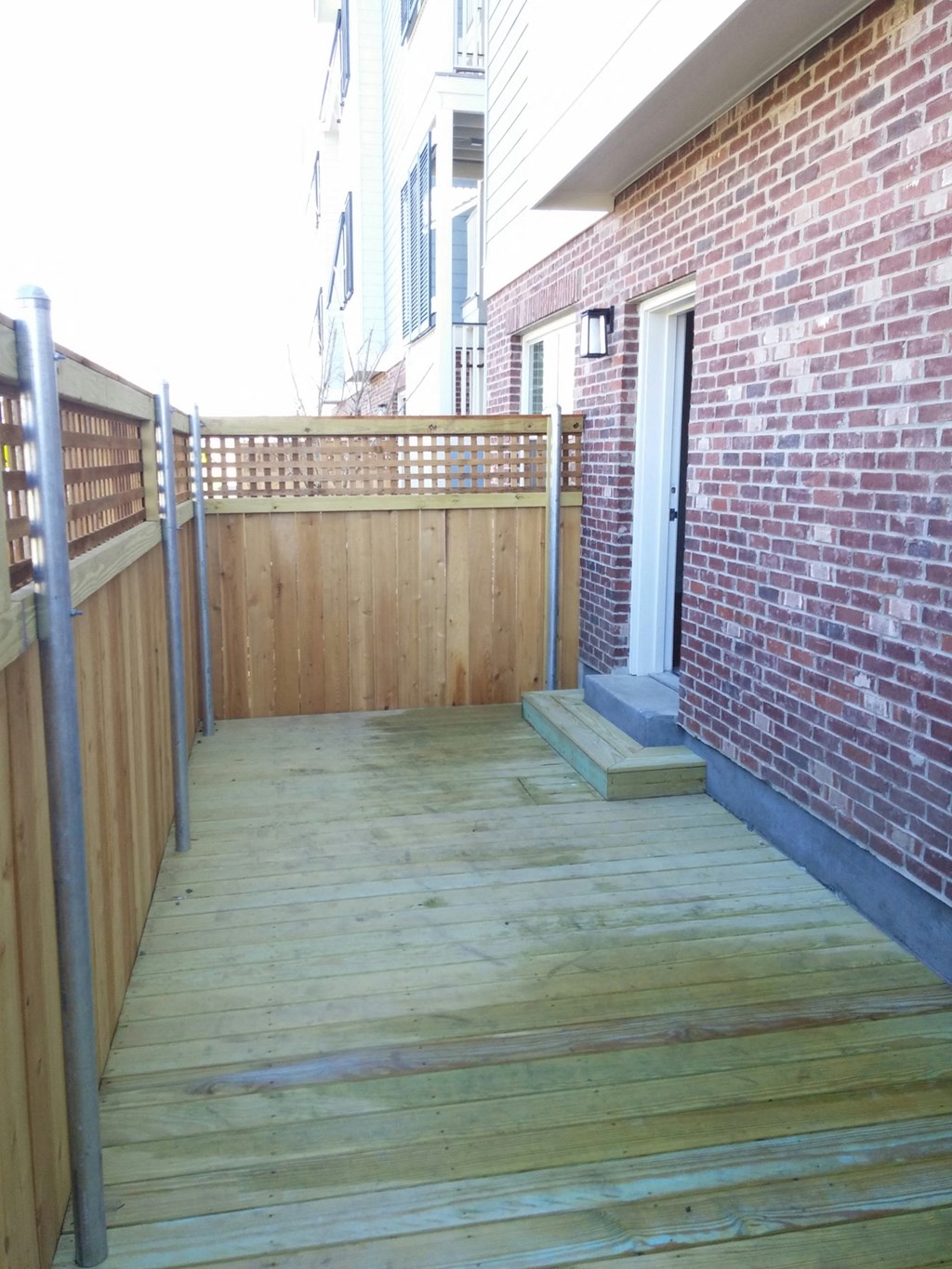 a wooden deck next to a brick building