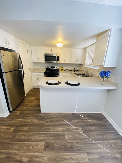a kitchen with white cabinets and stainless steel appliances