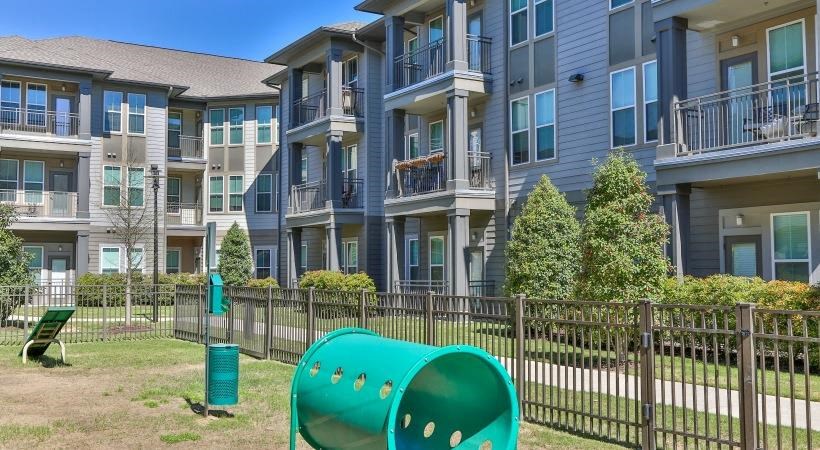 an apartment building with a green playground in front of it
