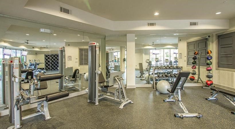 a gym with a lot of machines and weights