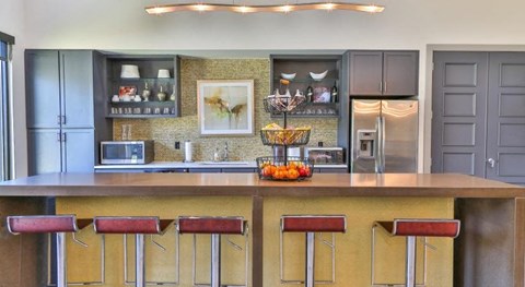 a kitchen with a large counter and bar stools