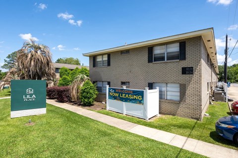 A Lila Place sign is in front of a brick building.