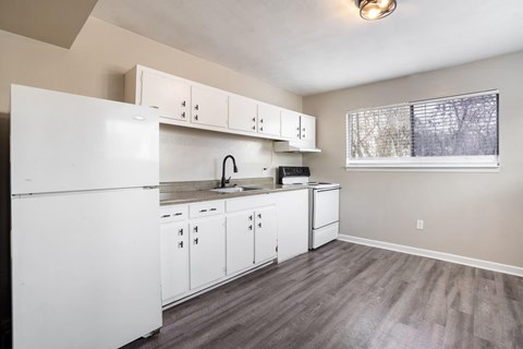 A kitchen with white appliances and cabinets.