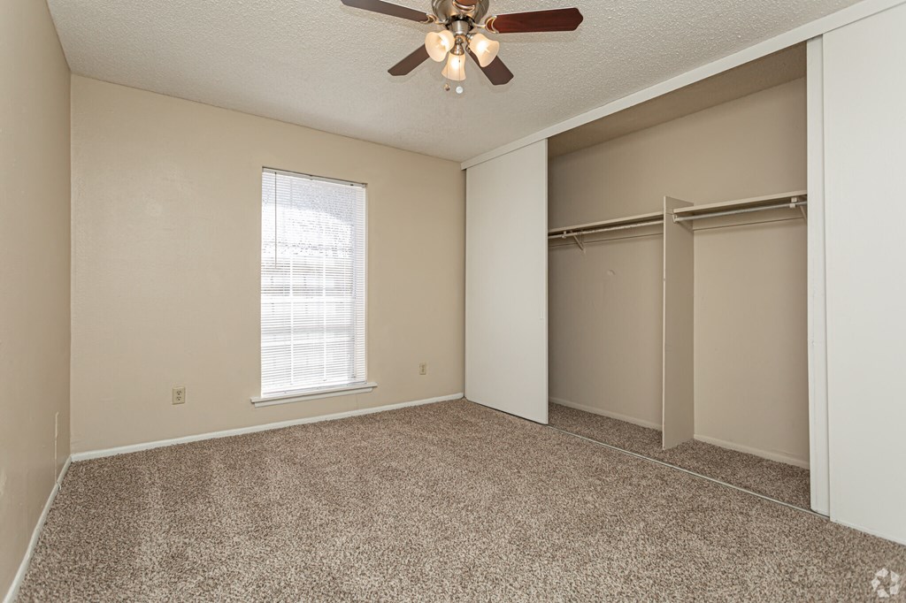 A room with a ceiling fan and a window.