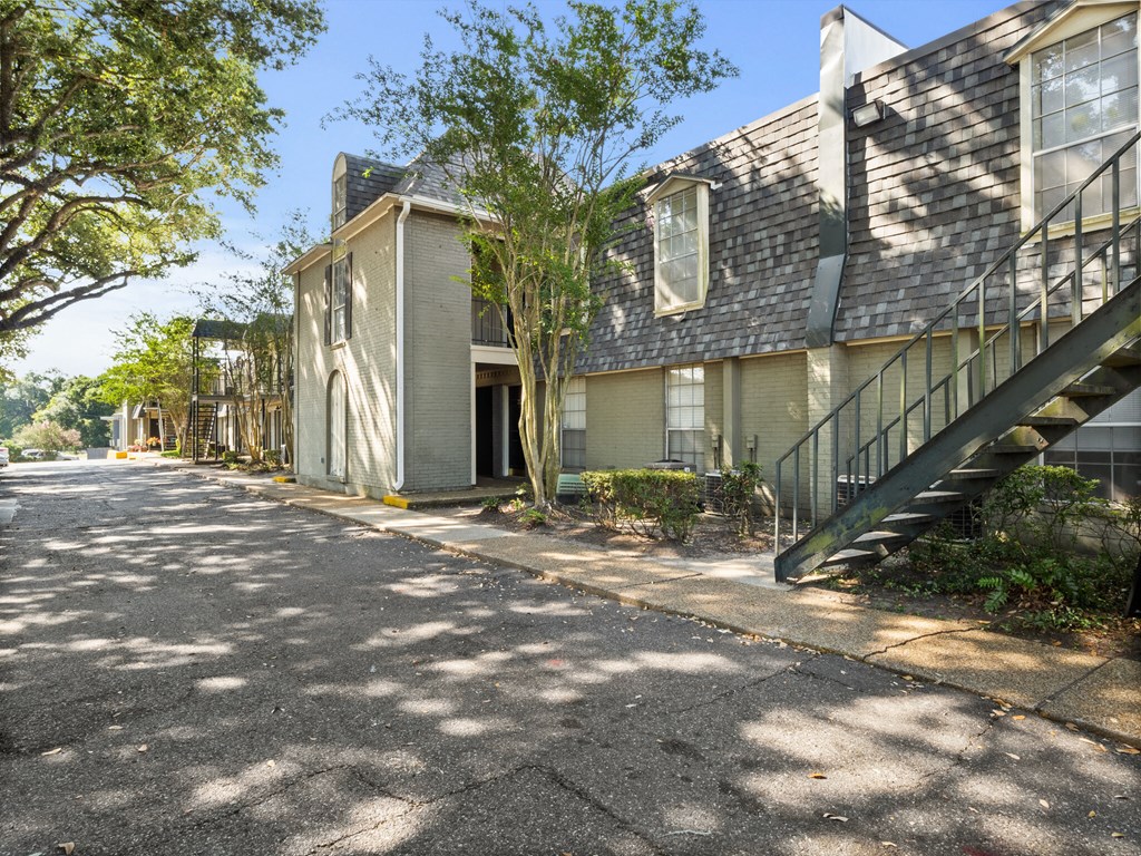 A sunny day at a quiet residential street with apartment buildings on either side.