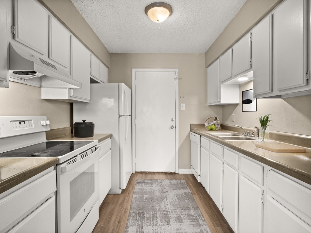 A kitchen with white appliances and cabinets.