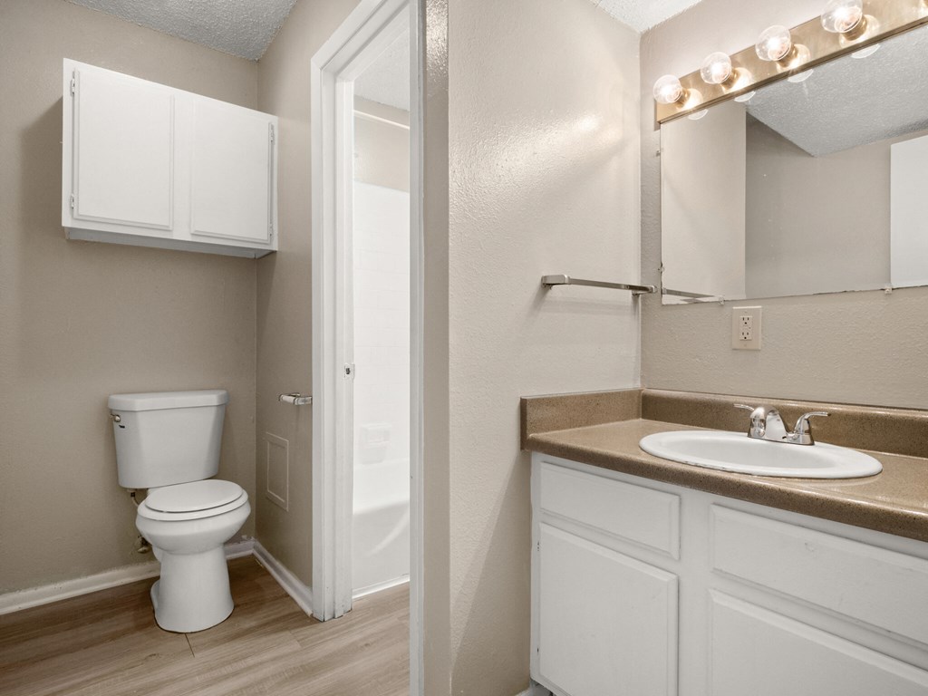 A white toilet sits in a bathroom next to a sink.
