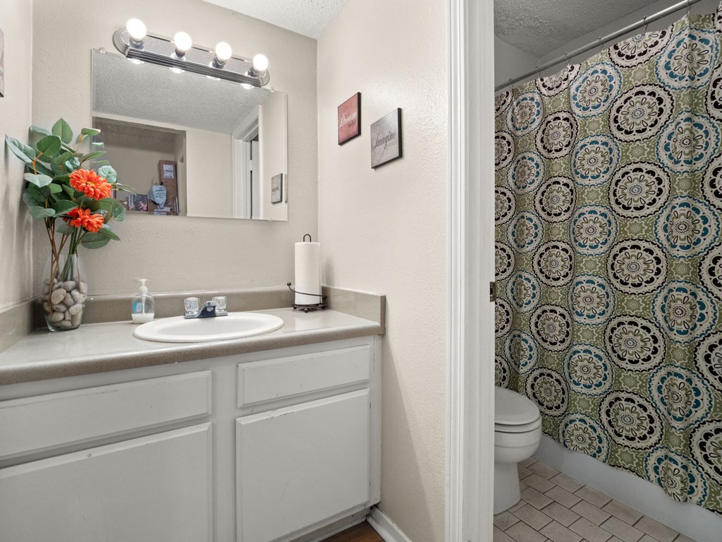 A bathroom with a patterned shower curtain and a white sink.