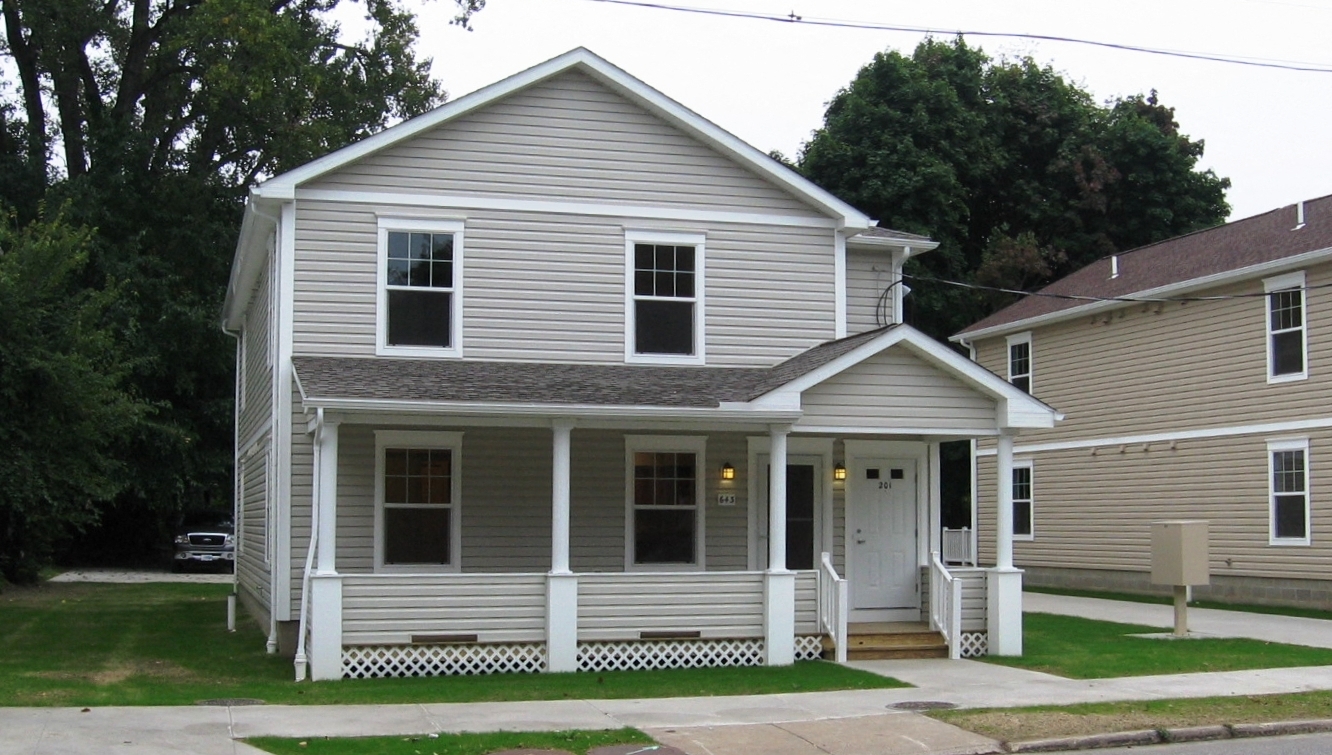 a white house with a white fence in front of it