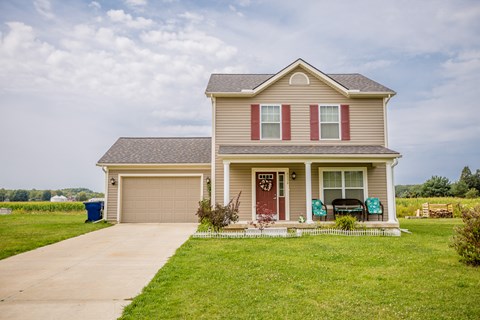 a beige house with a red door and a garage