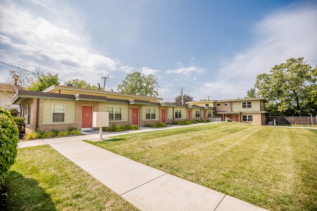 a row of houses with a lawn and sidewalk