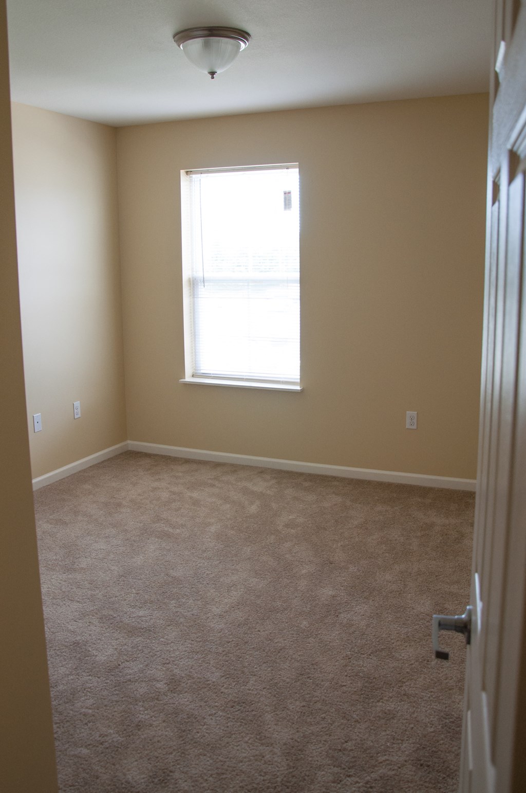 an empty room with a window and a door