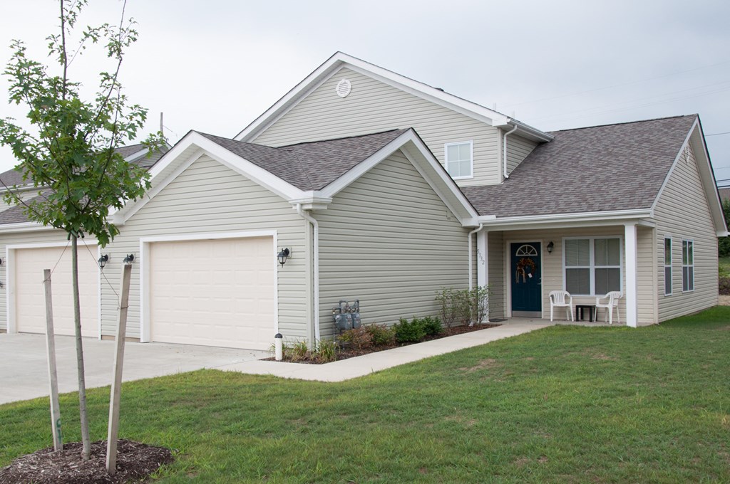 the front of a house with a lawn and a driveway