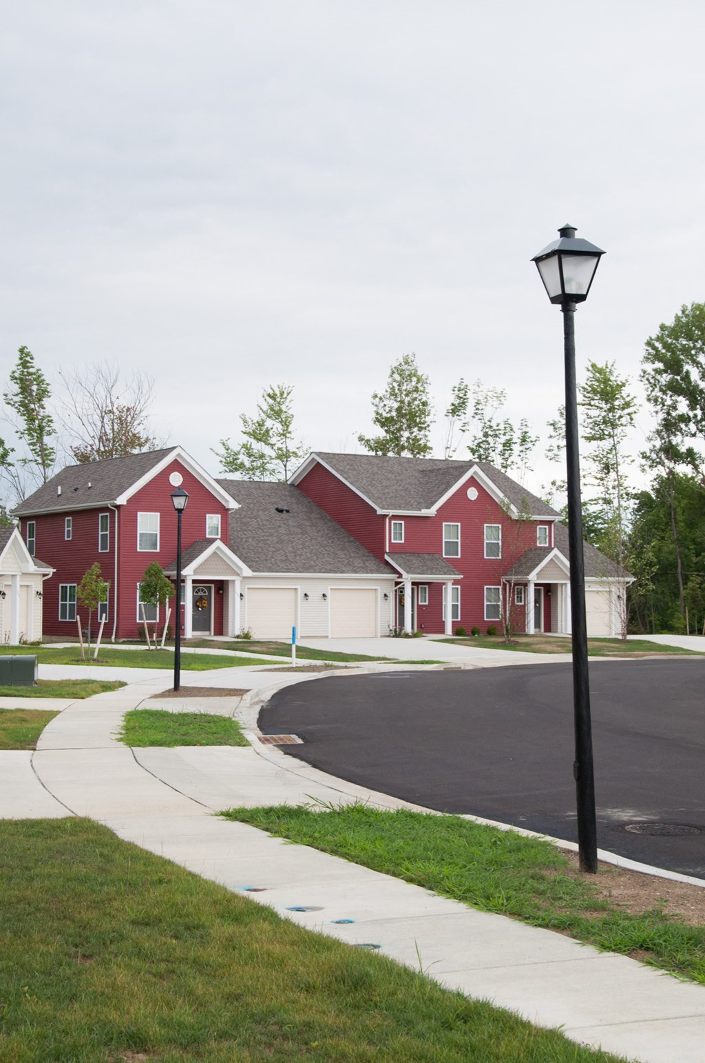 a row of red houses on a street with a street light
