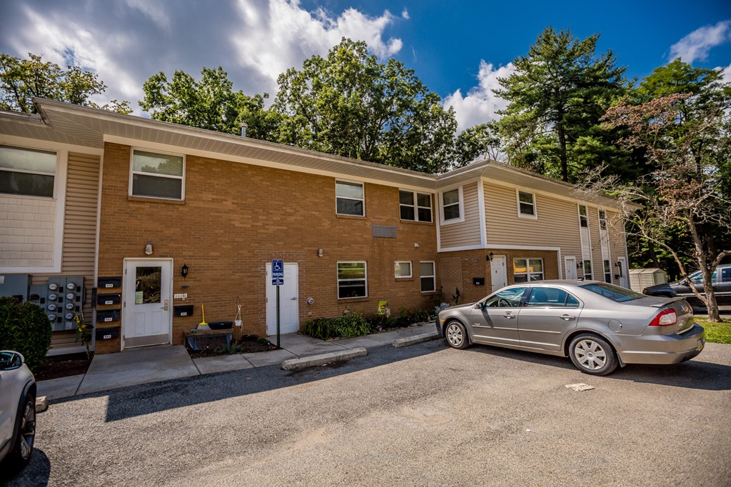 a brick apartment building with a car parked outside