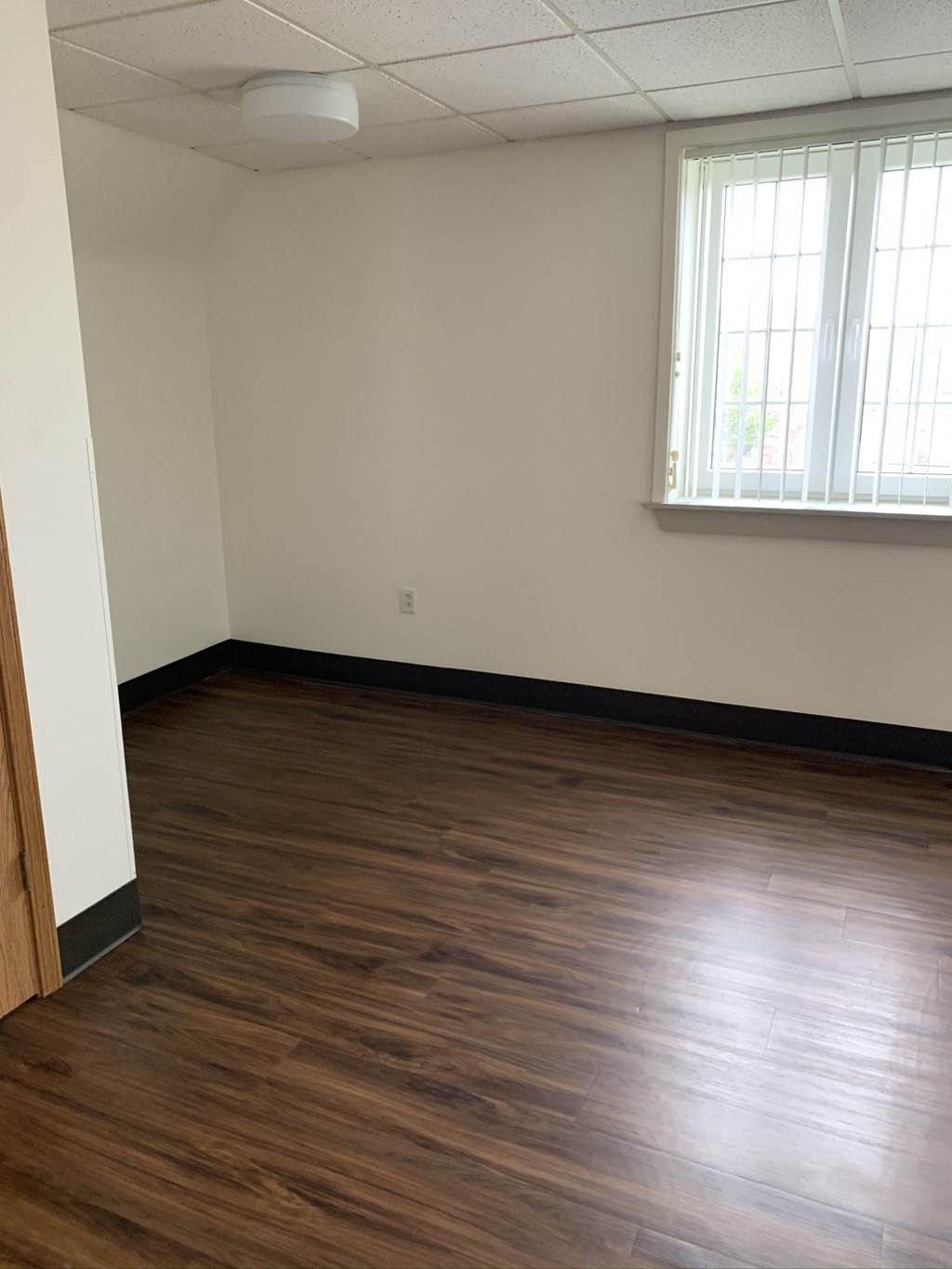 an empty room with wooden floors and a window