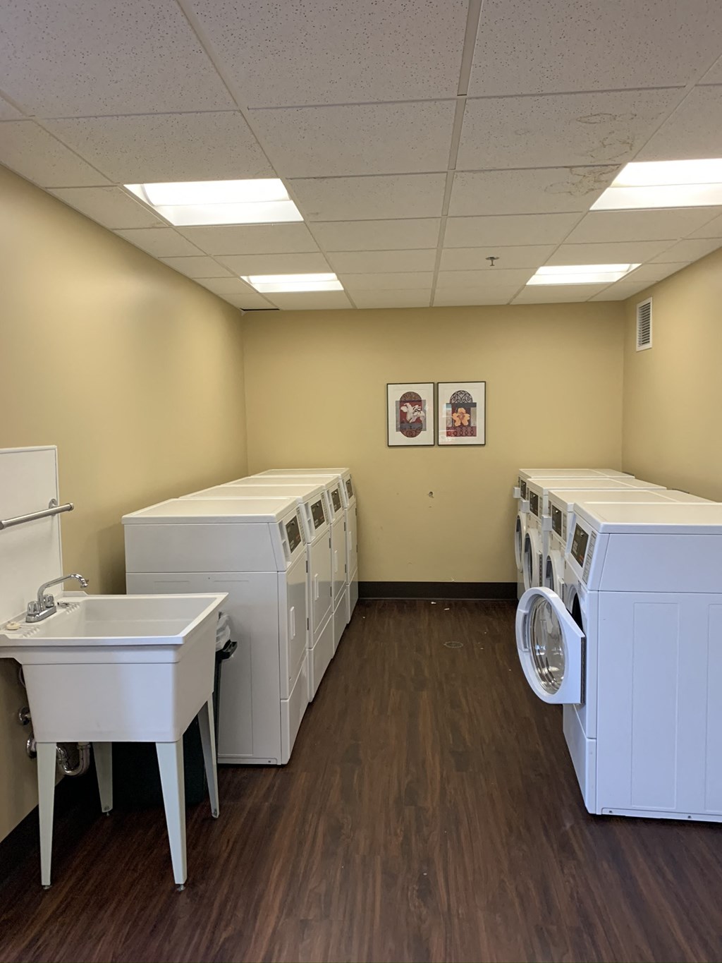 a laundry room with washers and dryers and a sink