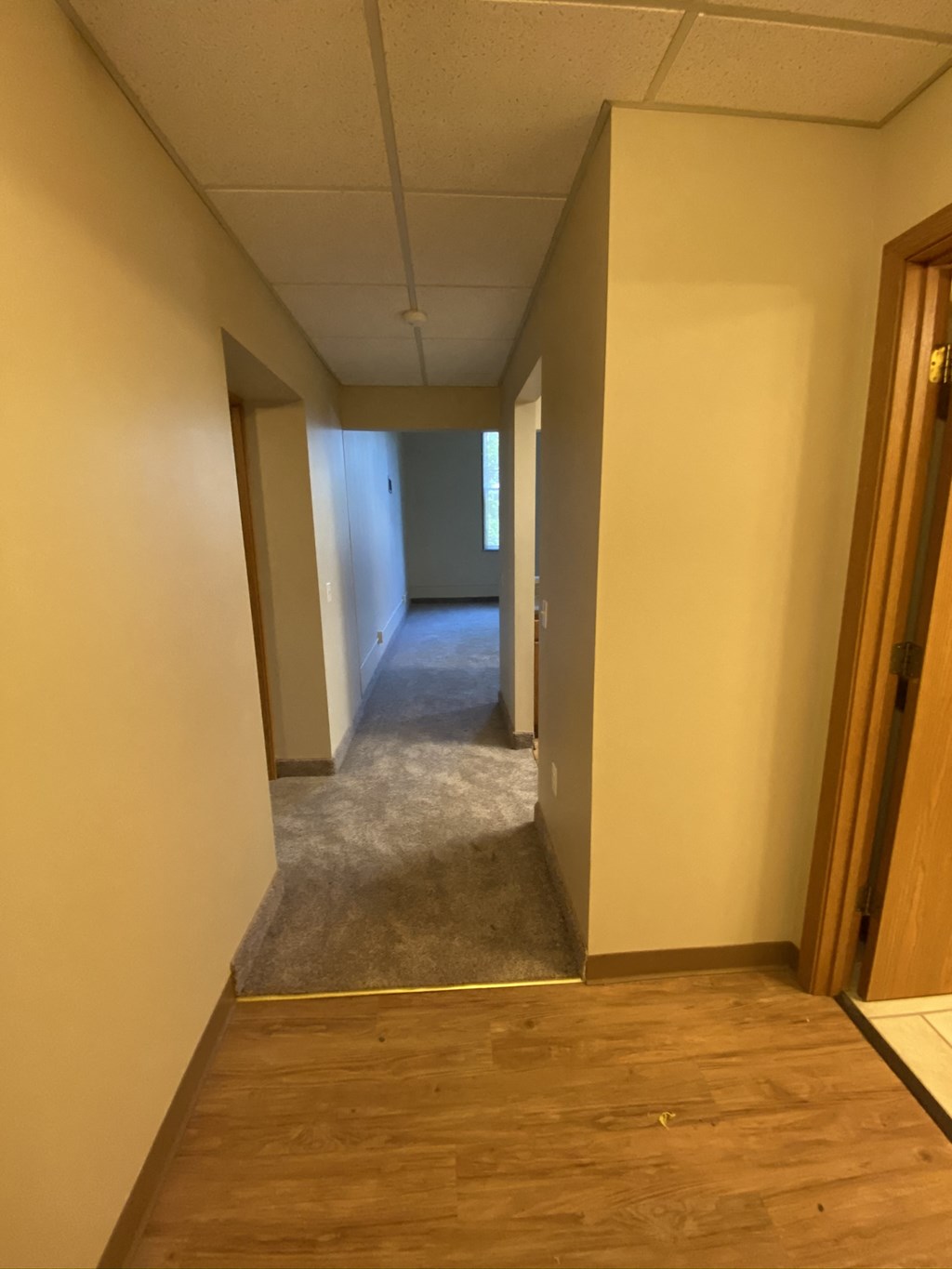 a view down a hallway with wood floors and white walls