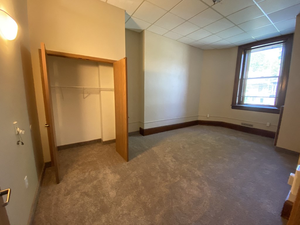 an empty room with a closet and a window