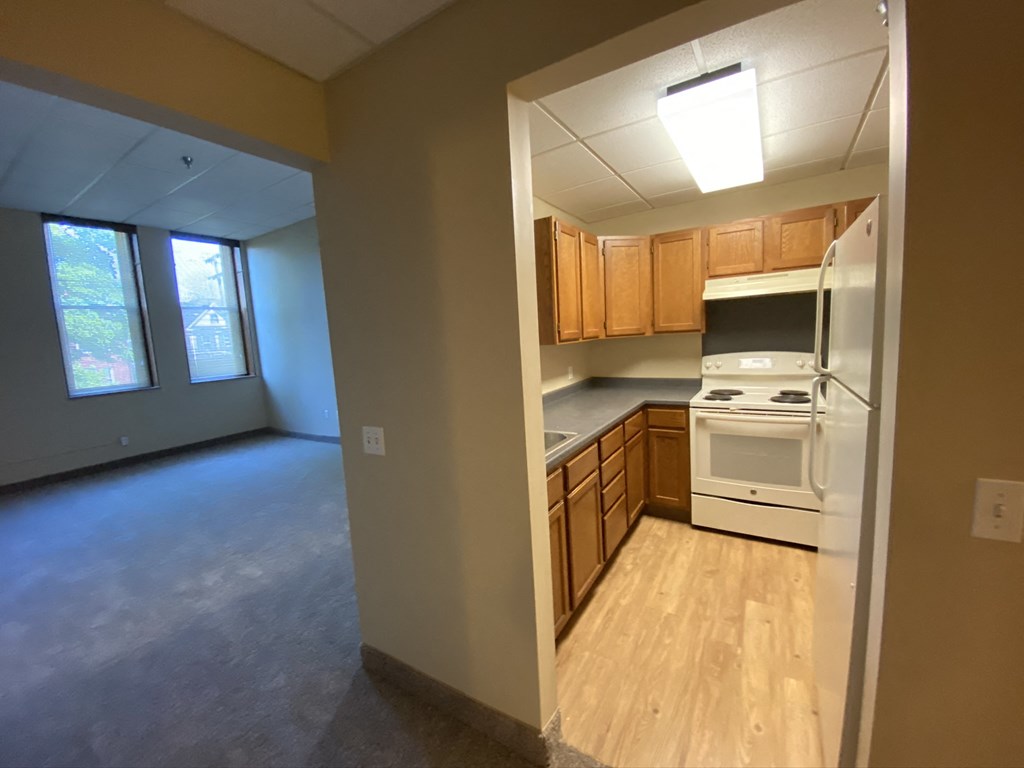 an empty kitchen with wooden cabinets and a white stove and oven
