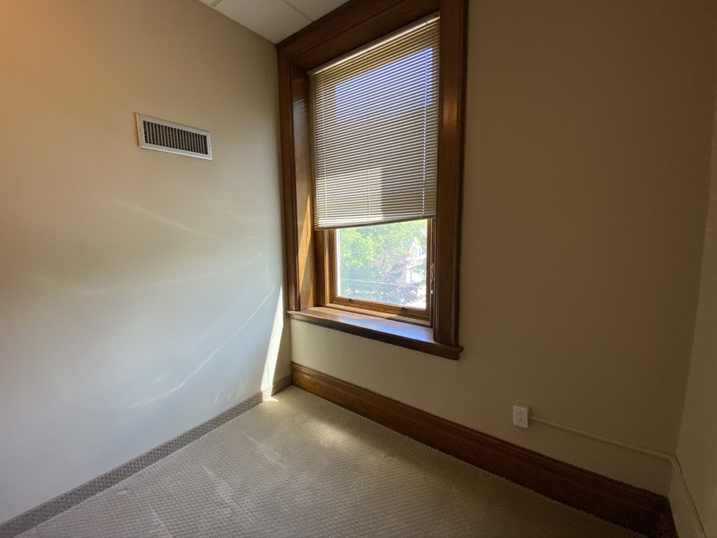 an empty room with a window and a radiator