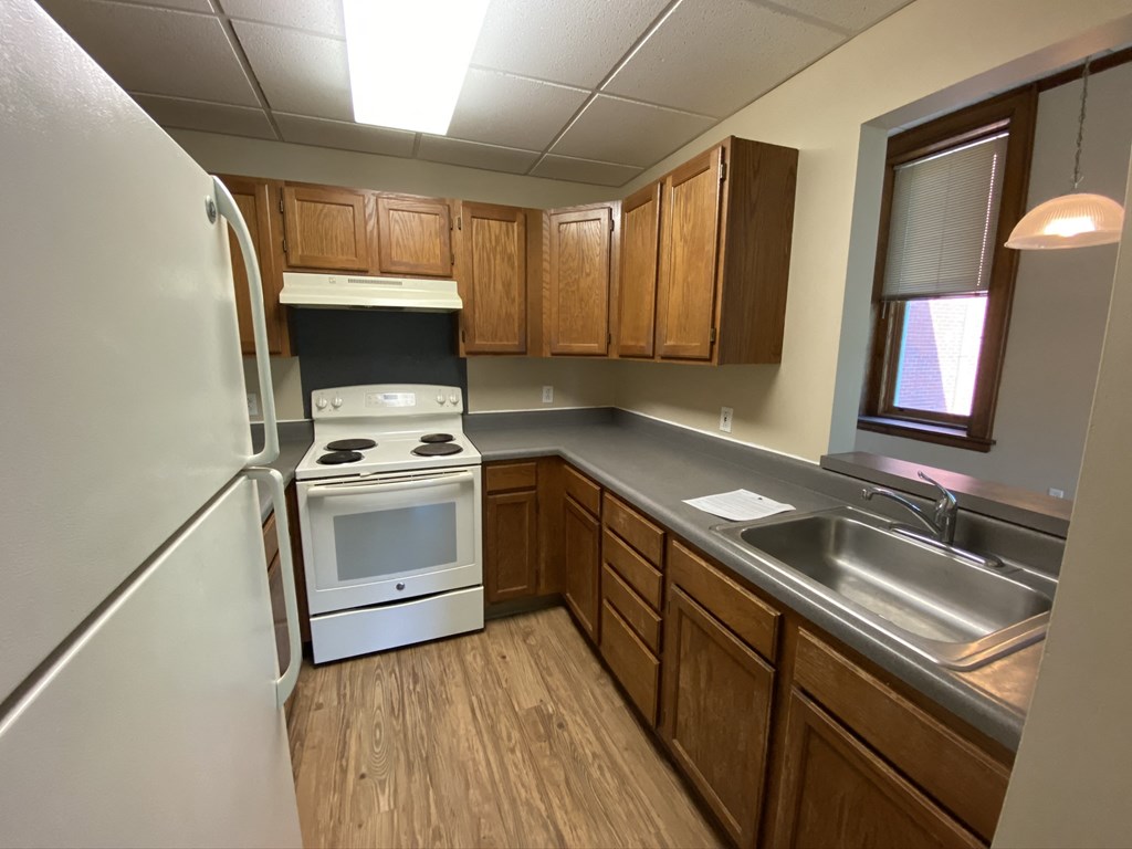 an empty kitchen with a stove refrigerator and sink