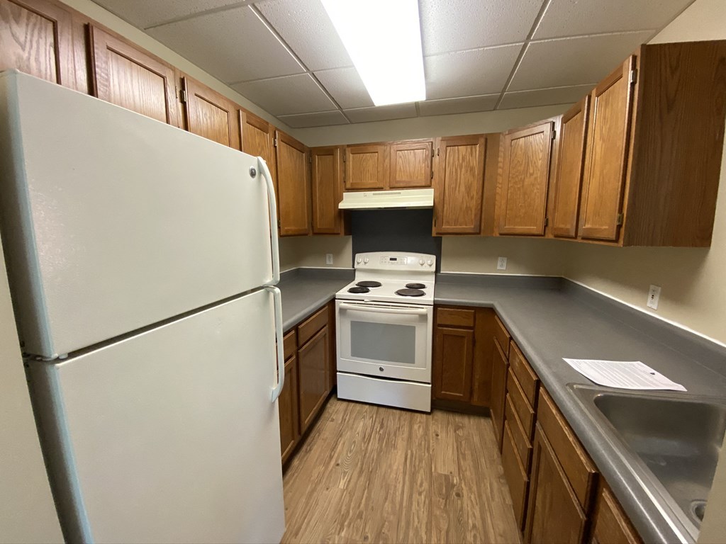 a kitchen with white appliances and wooden cabinets