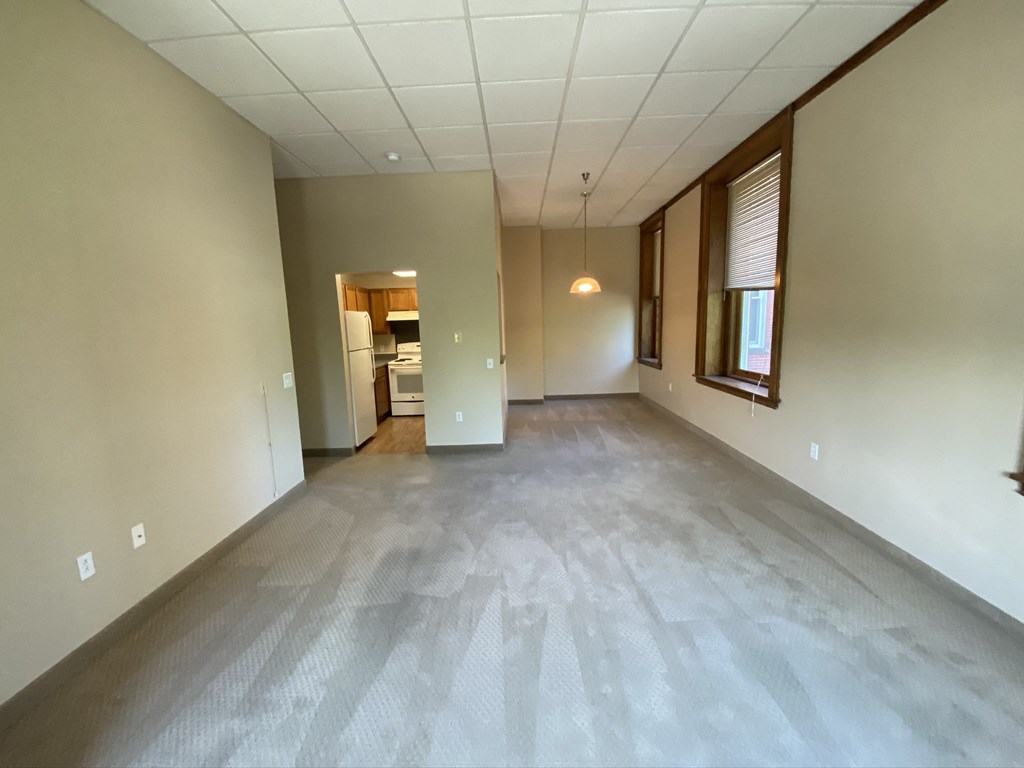 the living room and dining room of a new home with white walls and wood floors