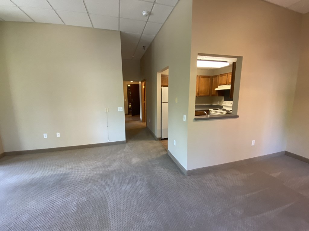 an empty living room with a mirror in the wall