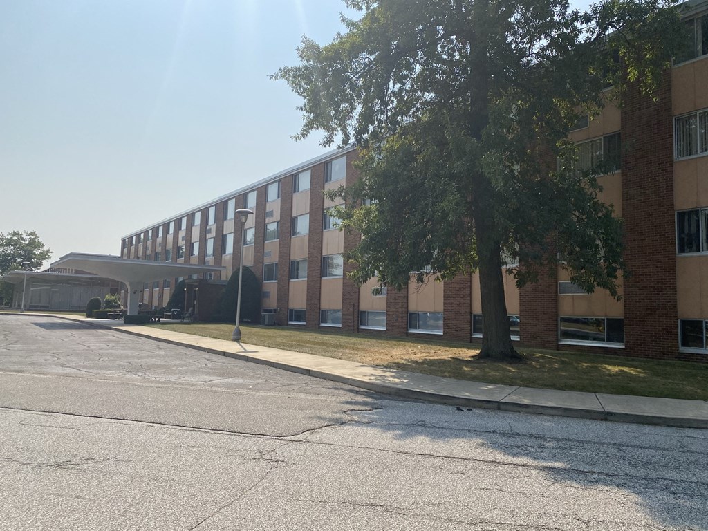 a large brick building with a tree in front of it