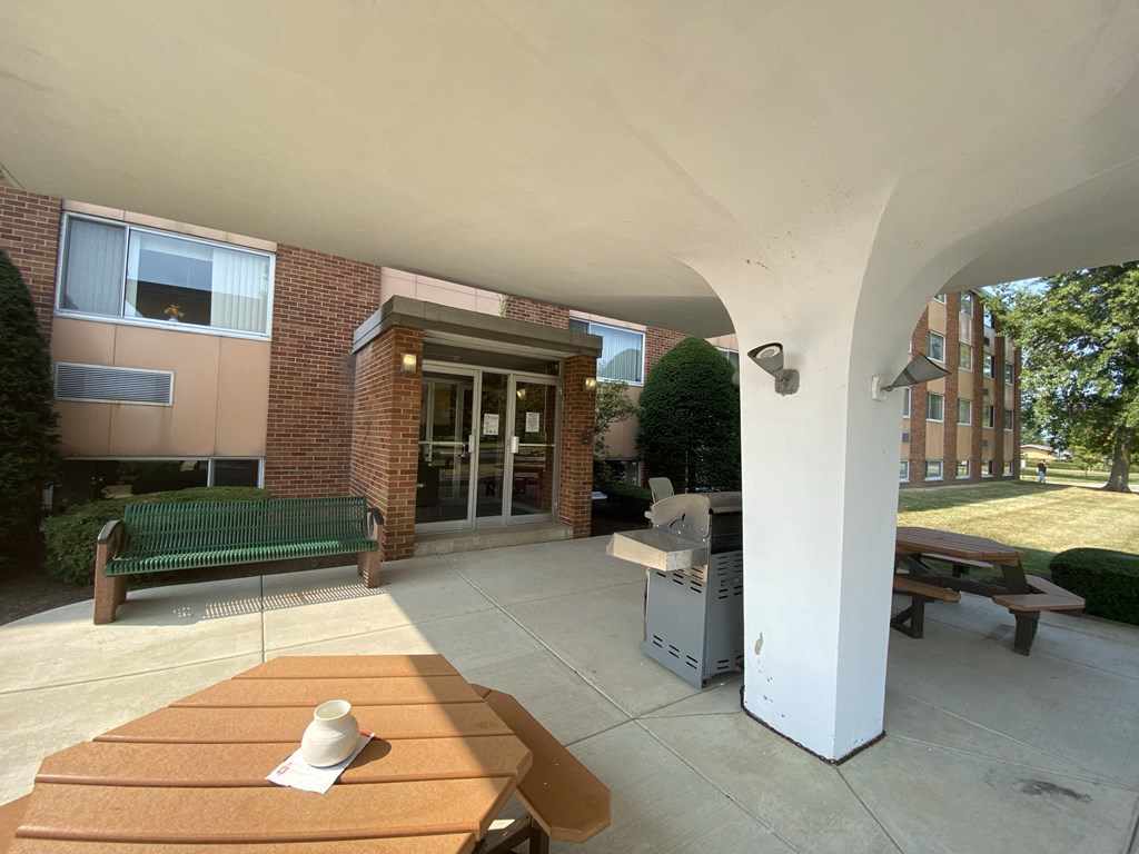 a view of a patio with a table and a grill