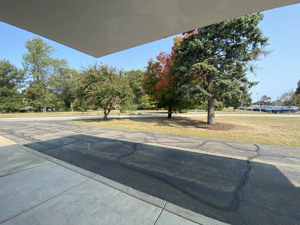 a view of a park with trees and a parking lot