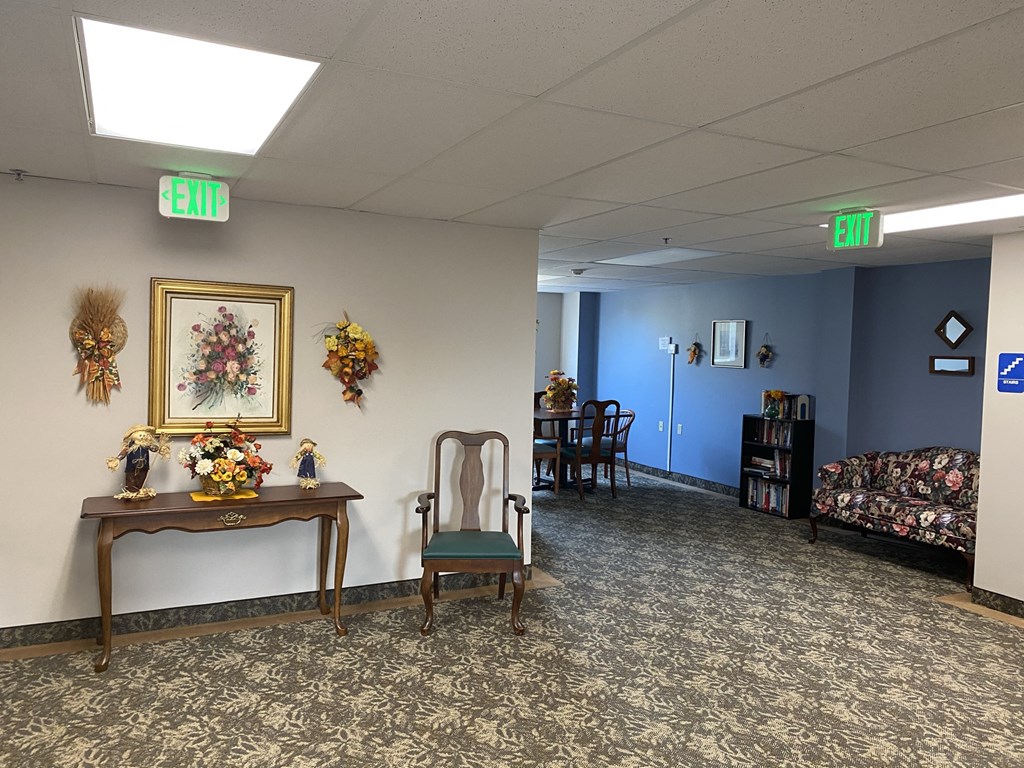 a room with a table with a chair and a painting on the wall and a