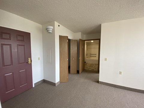 a view of a living room and a hallway with a purple door