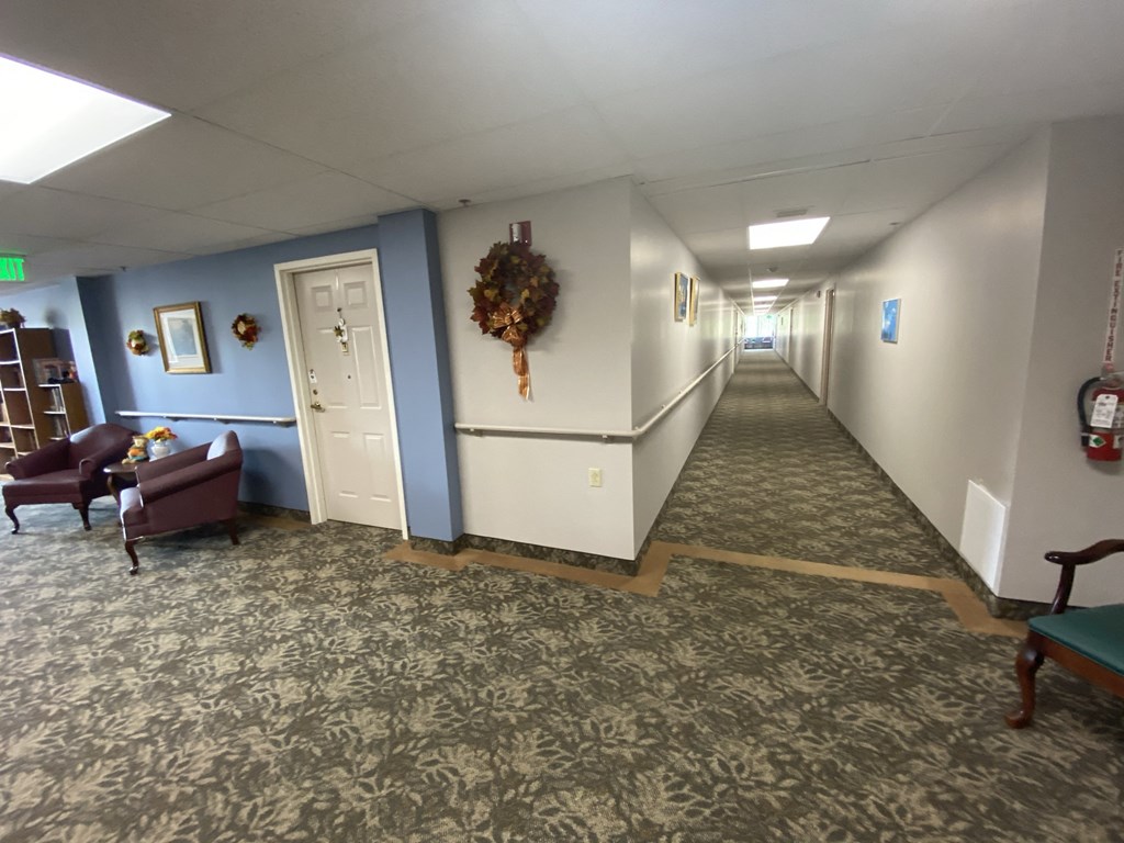 a long hallway with blue and white walls and a carpeted floor