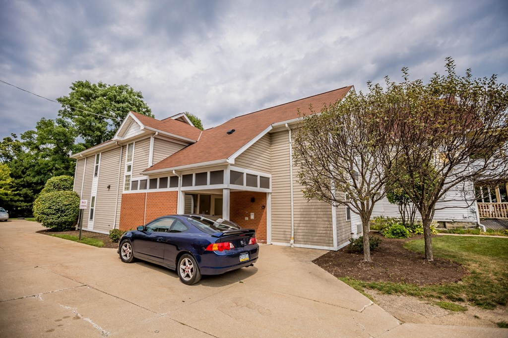 the front of a house with a car parked in the driveway