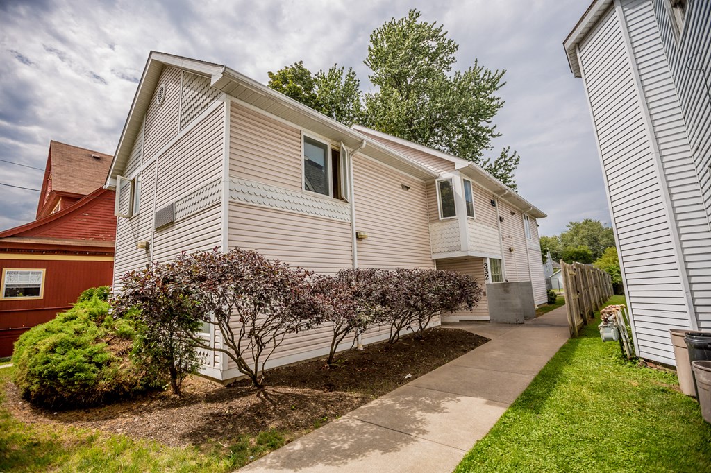a white house with a sidewalk in front of it