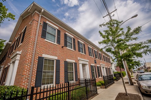 a red brick building with black windows and a black fence