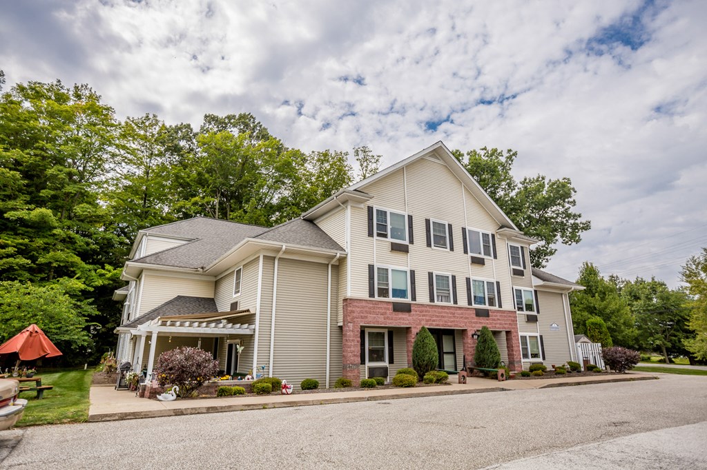 the view of a large house with a driveway and trees