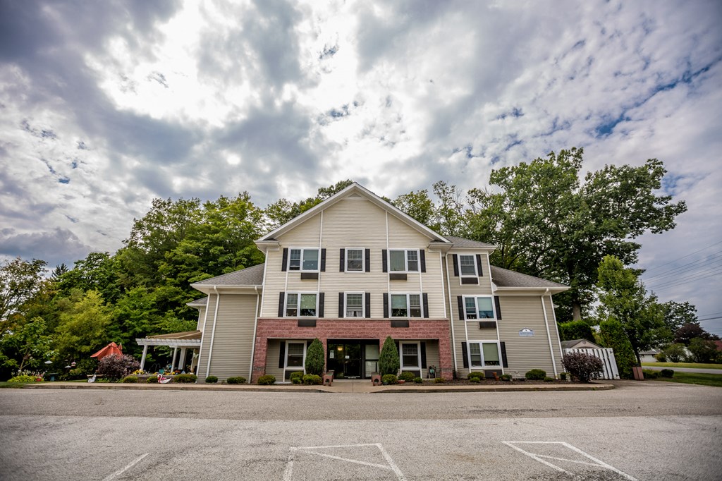 an apartment building with a parking lot and a cloudy sky