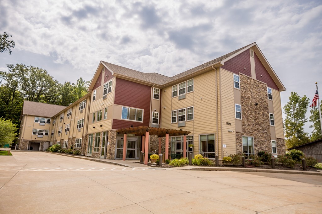 the exterior of a building with an flag and a parking lot