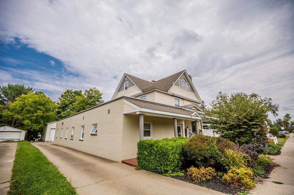 a cream colored house with a street in front of it