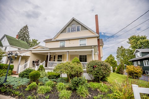 a white house with a garden in front of it