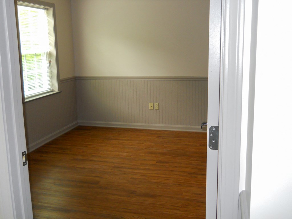 an empty room with wooden floors and a window