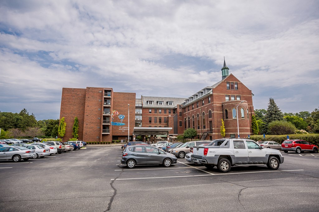 a parking lot filled with cars in front of a brick building