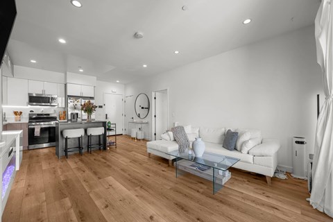 A modern living room with a white sofa and wooden flooring.