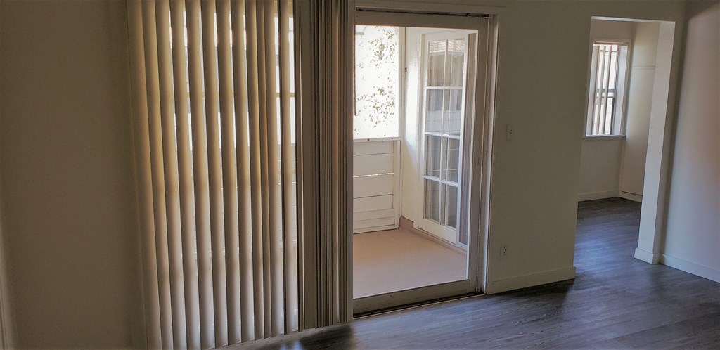 a living room with a window and a door to a room