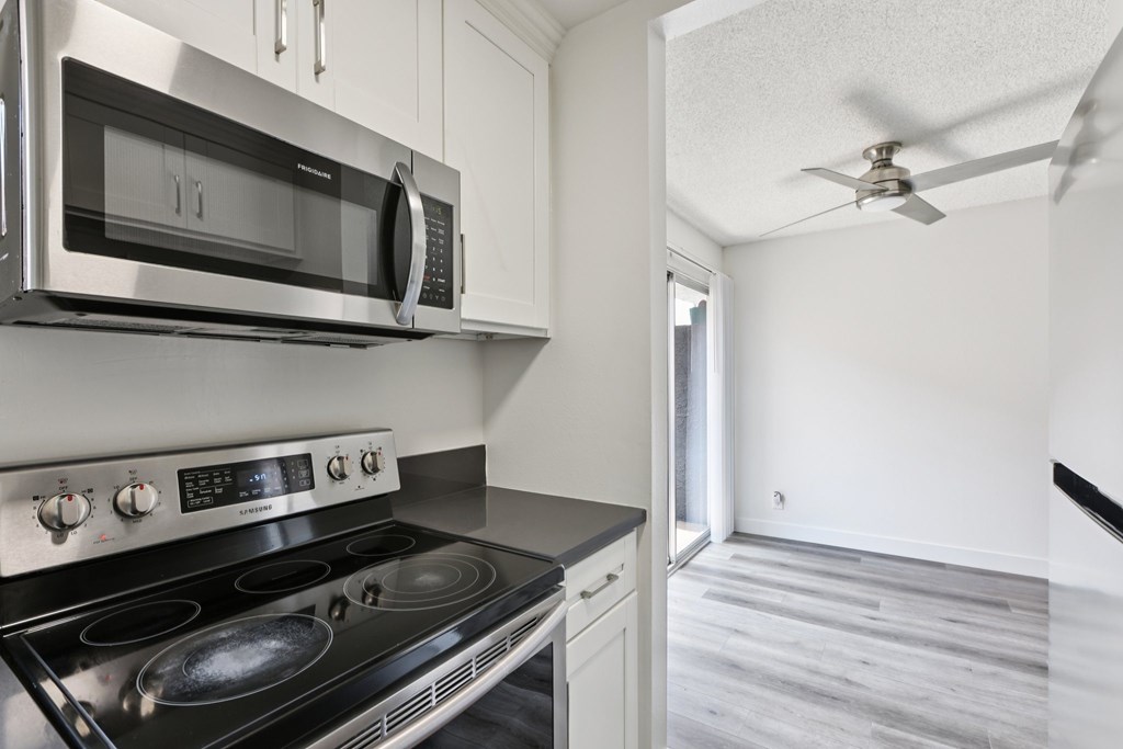 A modern kitchen with a stainless steel stove and microwave.