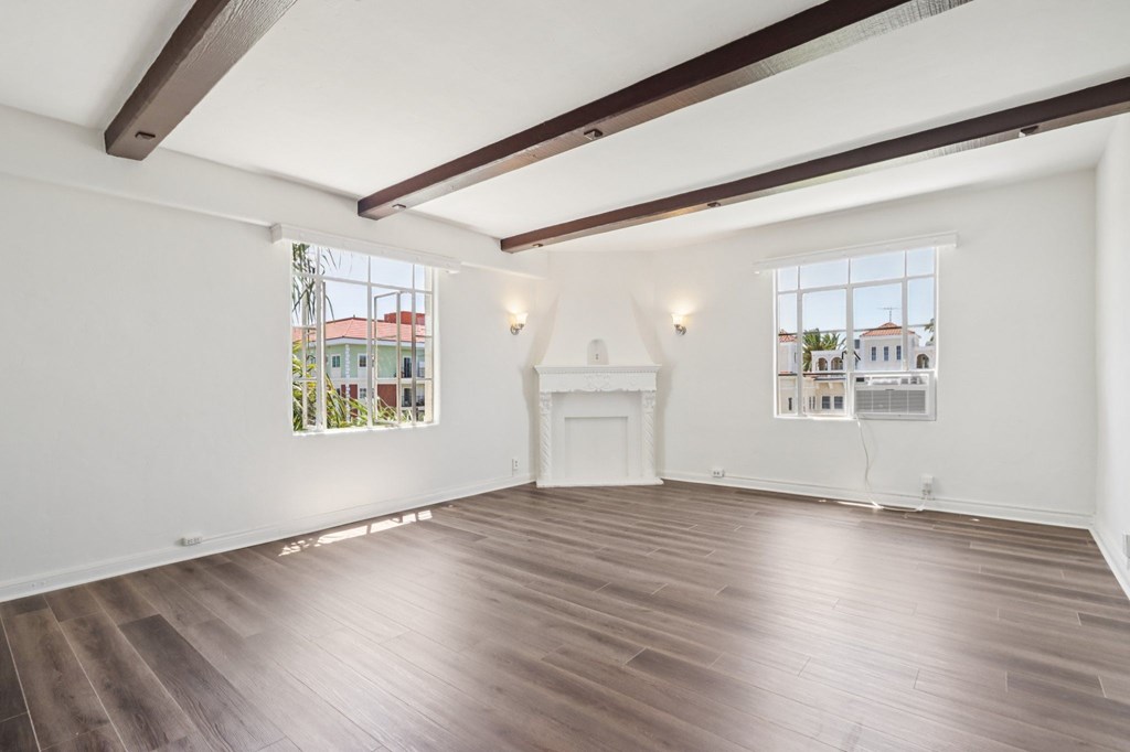 A large empty room with wooden floors and white walls.